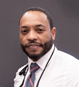 Here's an alt tag for the image: Headshot of a man in a white shirt and tie.