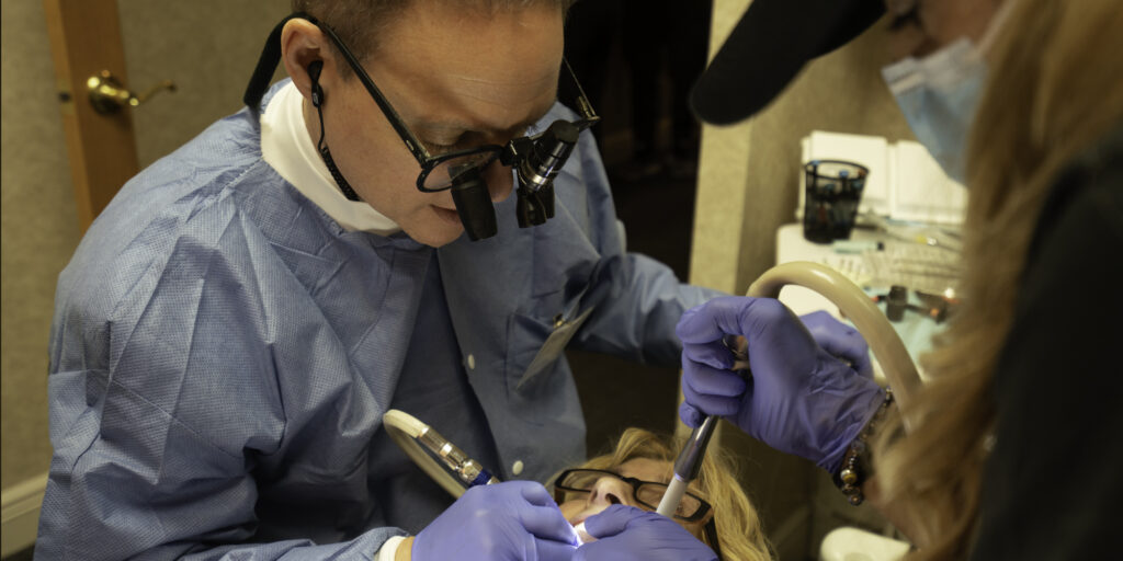 Dentist performing dental procedure on patient.