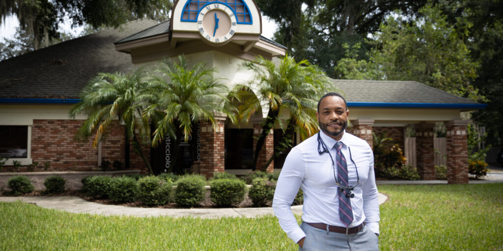 Smiling dentist standing outside his office. Smiling dentist standing outside his office.
